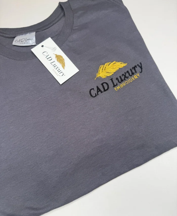 GREY EMBROIDERED TSHIRT WITH LEFT CHEST LOGO THATS SAYS CAD LUXURY HOMES