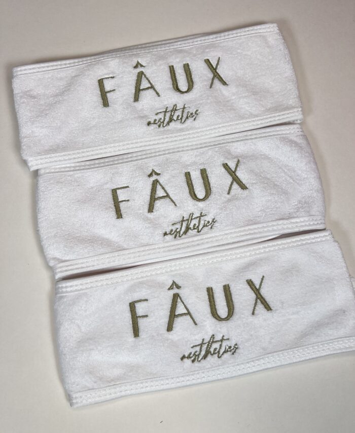 embroidered spa headband on laid on a neutral background