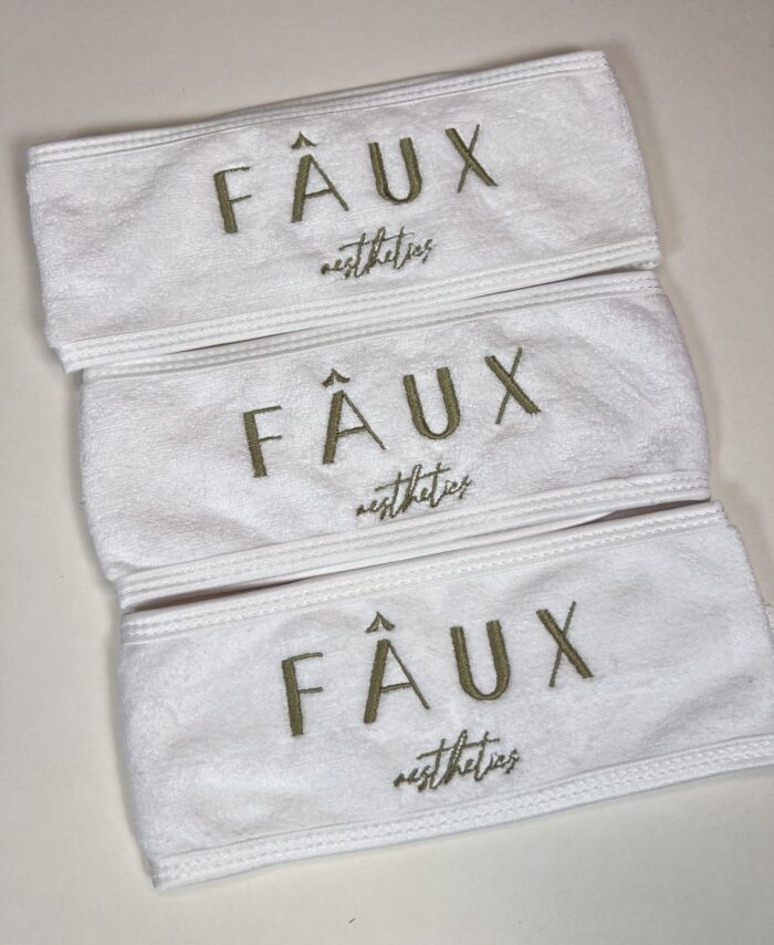 embroidered spa headband on laid on a neutral background