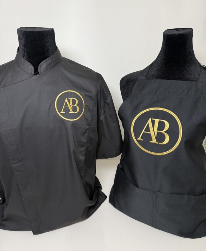personalised black apron with gold embroidered AB logo, premium custom workwear with front pockets